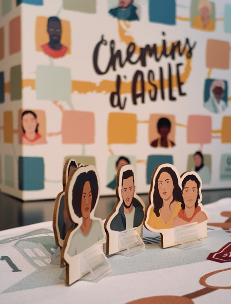 Le jeu "Chemins d'Asile" déployé sur une table de jeu.